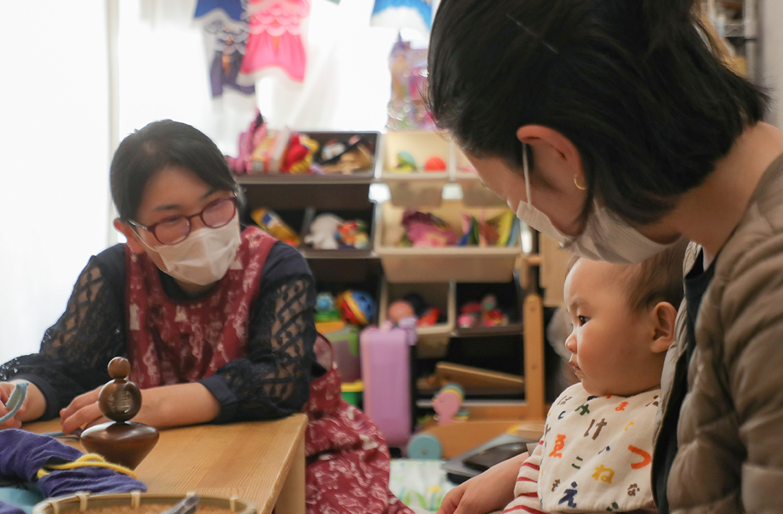 大久保さん、お母さん、赤ちゃんの三人がコミュニケーションしている写真。